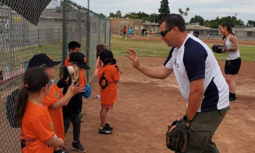 Kids playing catch with coaches