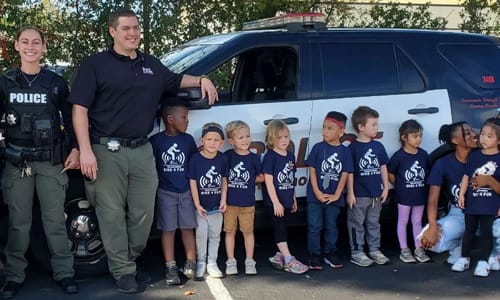 RCPD and groupd of kids taking picture in front of police car