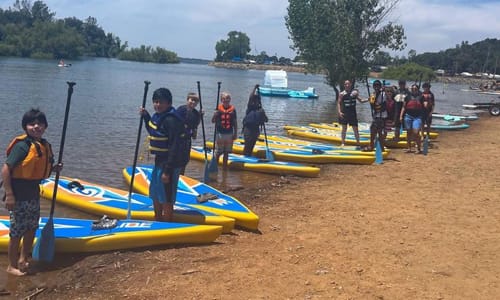 Group of kids getting ready to go out kayaking