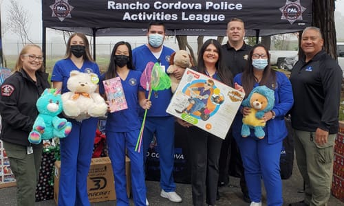 Medical volunteers in scrubs with masks next to event volunteers at Christmas in Cordova
